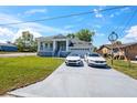 Charming home featuring a manicured lawn and a driveway with two stylish vehicles parked out front at 8622 Inwood Dr, Hudson, FL 34667