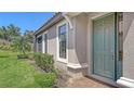 Charming home with a green front door, complemented by manicured landscaping and a brick walkway at 12619 Sorrento Way, Bradenton, FL 34211