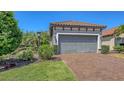 Charming home featuring a two-car garage, paver driveway, and meticulously maintained landscaping at 12619 Sorrento Way, Bradenton, FL 34211