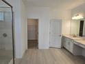 Elegant bathroom featuring double vanity, linen cabinets, glass shower, and walk-in closet at 1591 Laurel Brook Ln, Port Charlotte, FL 33953