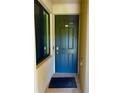 A dark blue front door with black hardware, set against a neutral wall next to a window at 17108 Vardon Ter # 401, Bradenton, FL 34211