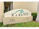 Close-up of the 'Marquee en Ville' sign at 235 Cocoanut Avenue with lush landscaping at 235 Cocoanut Ave # 108B, Sarasota, FL 34236