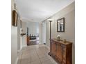 Hallway featuring tile flooring with decorative cabinet and mirror at 2749 Riverbluff Pl # V65, Sarasota, FL 34231
