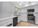 Clean kitchen featuring stainless steel appliances, white cabinets, and ample counter space at 2749 Riverbluff Pl # V65, Sarasota, FL 34231