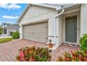 Close-up of the front exterior, showcasing the two-car garage, front door, and brick-paved walkway at 3924 Candia Ave, North Port, FL 34286