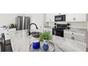 Close-up of the kitchen island, featuring marble countertops and a stylish faucet and sink at 3924 Candia Ave, North Port, FL 34286