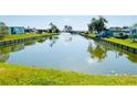 Scenic view of a tranquil canal with a fountain, lined by lush green grass, creating a serene ambiance at 415 Oakwood W Blvd, Sarasota, FL 34237