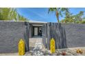 Eye-catching home with textured gray walls, yellow decor, and an inviting open gate to the front entrance at 4857 Stevens Dr, Sarasota, FL 34234