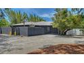 Contemporary home's exterior showcasing a textured gray facade, landscaped with lush greenery and a charming driveway at 4857 Stevens Dr, Sarasota, FL 34234