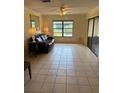 Bright living room with tile flooring, ceiling fan, and sliding glass doors to the outdoors at 5014 Barrington Cir # 2102, Sarasota, FL 34234