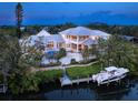 Waterfront home with private pool, dock, and manicured lawn overlooking a canal, offering serene outdoor living at 5132 Jungle Plum Rd, Sarasota, FL 34242