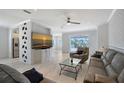 Comfortable living room with tile floors, modern furnishings, and glass sliding doors to the outdoor lanai and pool at 5320 Tide Point Way, Bradenton, FL 34208