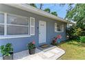 Close-up of front door with welcome mat and surrounding flower pots at 5710 16Th W St, Bradenton, FL 34207