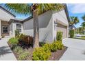 Attractive exterior view of home showcasing verdant landscaping, including a palm tree, and an attached two-car garage at 5985 Amberly Dr, Bradenton, FL 34208