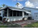 A view of the back exterior with a sunroom, a patio, an AC unit, and storage space at 6074 Arlene Way # 5, Bradenton, FL 34207