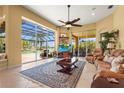 Spacious living room with large windows overlooking the pool and lake, providing abundant natural light at 6143 9Th Avenue Ne Cir, Bradenton, FL 34212