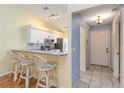 Bright kitchen and entrance featuring white cabinets, bar seating, and tile flooring at 642 N Jefferson Ave # 13, Sarasota, FL 34237