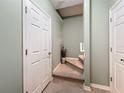 Hallway leading to stairs features light green walls, white doors, and carpeted stairs with an attractive entry at 7346 Skybird Rd # 417, Bradenton, FL 34209
