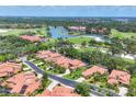 Scenic aerial view of the golf course community with lush greenery and serene lake at 7551 Calle Facil, Sarasota, FL 34238