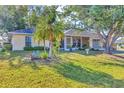 Beautifully landscaped front yard with lush greenery, palm trees, and a cozy screened-in porch at 9366 Westminster Ave, Englewood, FL 34224