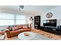 Cozy living room featuring a leather sofa, hardwood floors, and plenty of natural light at 1010 68Th Nw St, Bradenton, FL 34209
