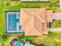 Aerial view of a tile-roof home with screened pool and lush green lawn at 13112 Swiftwater Way, Bradenton, FL 34211