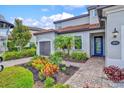 Charming home entrance with a brick pathway and vibrant landscaping at 13112 Swiftwater Way, Bradenton, FL 34211
