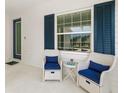 Cozy front porch features stylish seating with blue cushions, creating a welcoming outdoor space at 13169 Steinhatchee Loop, Venice, FL 34293