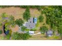 Aerial view of the home showing its pool, solar panels, outbuildings, and privacy on a large lot at 140 Cowpen Ln, Sarasota, FL 34240