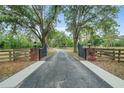 Long private driveway with gate and beautiful mature shade trees leading to the home at 140 Cowpen Ln, Sarasota, FL 34240