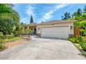 Lovely home featuring a two-car garage, stone accents, and professionally landscaped front yard at 1715 Fossil Dr, Englewood, FL 34223