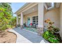 Inviting front porch with decorative columns, a blue door, and outdoor seating at 1715 Fossil Dr, Englewood, FL 34223