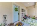 Welcoming front porch with a colorful wreath, seating area, and vibrant tropical-themed welcome mat at 1715 Fossil Dr, Englewood, FL 34223