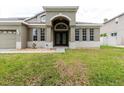 Inviting front entrance with decorative double doors, stone accents, and a well-kept lawn at 20316 Natures Corner Dr, Tampa, FL 33647