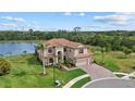 Stunning lakefront property featuring lush landscaping and a beautiful tile roof at 20831 Valprato Ct, Venice, FL 34293