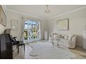Cozy living room featuring a modern area rug, piano, and large windows showcasing the outdoors at 20831 Valprato Ct, Venice, FL 34293