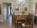 Traditional dining room featuring a wooden table, tiled flooring, and decorative wall art at 2181 Pine Gardens Trl, Sarasota, FL 34231
