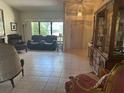 Cozy living room with tile flooring, furniture set, and a large window providing ample light at 2181 Pine Gardens Trl, Sarasota, FL 34231