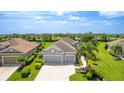 Aerial view showcasing the well-maintained home with lush lawn and tropical landscaping at 2240 Crystal Lake Trl, Bradenton, FL 34211