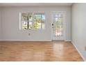 Bright living room featuring wood floors, a window overlooking the front yard and a decorative front door at 2606 Bismark Way, Sarasota, FL 34231
