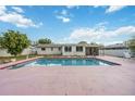Backyard pool with a pink deck and well-maintained landscaping at 2606 Bismark Way, Sarasota, FL 34231