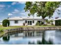 The back of the house features a waterfront view, white roof, and a patio area ideal for relaxing at 4102 Lakewood Ave, Bradenton, FL 34208