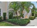 Two-story condo unit with trimmed hedges, manicured lawn, and stairway at 4254 Vicenza Dr # B, Venice, FL 34293