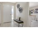 Bright foyer featuring tiled floors, a bench with decorative pillow, and modern metal wall art at 4812 Greywood Ln, Sarasota, FL 34235