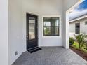 Inviting front porch features a decorative glass door, brick floor, and an exterior view at 4927 Carova Way, Bradenton, FL 34211