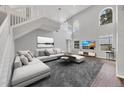 Bright living room with soaring ceilings, large windows, and a comfortable seating area, showcasing modern decor at 5561 Burnt Branch Cir, Sarasota, FL 34232