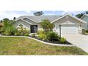 Charming single-story home with a well-manicured lawn, a two car garage and lush tropical landscaping at 5750 Carriage Dr, Sarasota, FL 34243