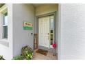 Charming entryway with a decorative sign, flamingo, and potted plants creates a welcoming ambiance at 6094 Amberly Dr, Bradenton, FL 34208