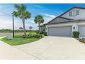 Wide concrete driveway leads to the two-car garage of this townhome with light gray exterior at 6094 Amberly Dr, Bradenton, FL 34208