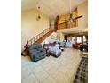 Spacious living room features tile flooring, high ceilings, and staircase at 6265 Viola Ln, New Port Richey, FL 34653